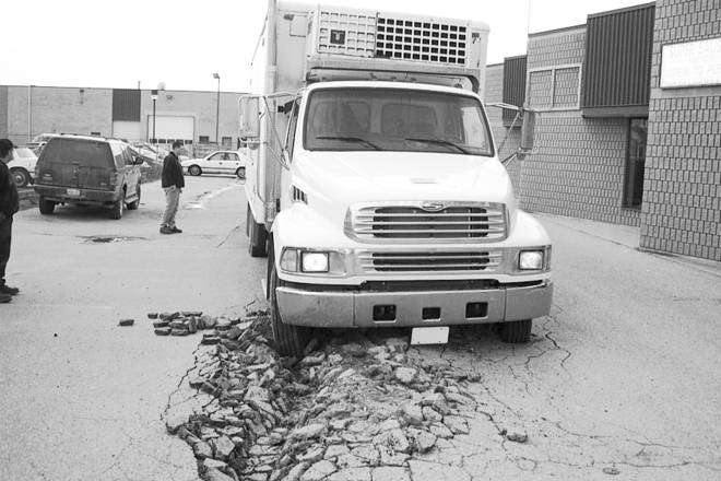truck over severely damaged concrete parking lot